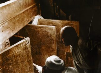 Carter y dos colaboradores examinan la tumba del faraón, que tiene unas proporciones ridículas para un soberano de la XVIII dinastía, lo que indica que su fallecimiento tuvo lugar de modo surpresivo.