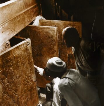 Carter y dos colaboradores examinan la tumba del faraón, que tiene unas proporciones ridículas para un soberano de la XVIII dinastía, lo que indica que su fallecimiento tuvo lugar de modo surpresivo.