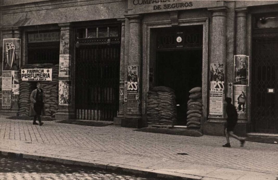 Dos transeúntes por una calle de Madrid durante la Guerra Civil (BNE).